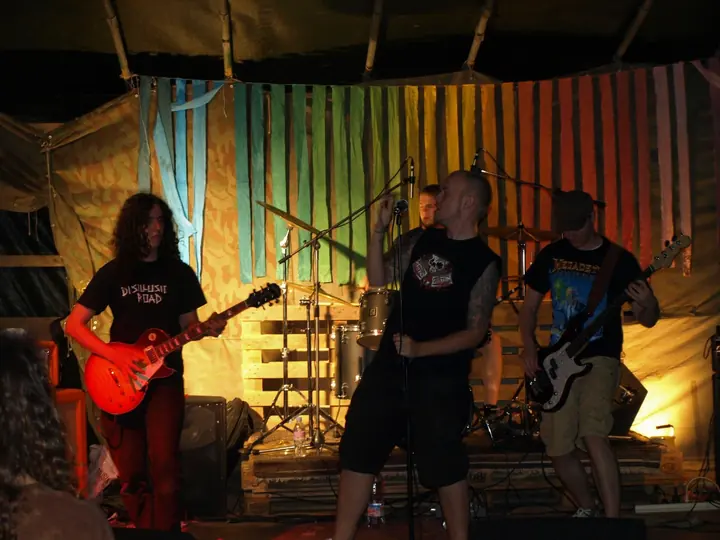 Eine Rockband spielt auf der kleinen Holzbühne.