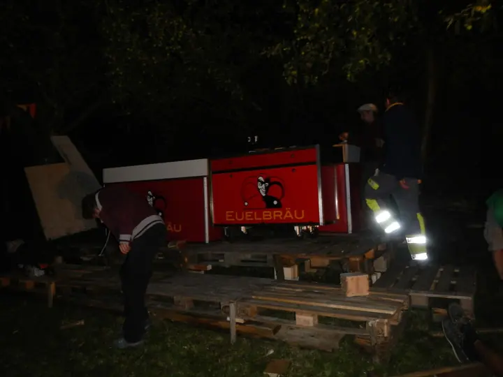 Der rot beleuchtete Euelibräu-Stand steht auf dem nächtlichen Festivalgelände.