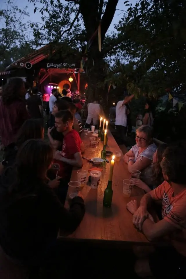 Festivalpublikum steht nachts vor der rot beleuchteten Bühne.