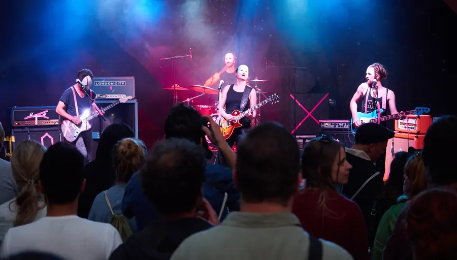 Eine Band spielt auf der Bühne vor dem Publikum.