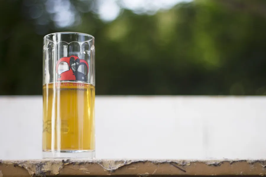 Ein Eidberger-Openair-Glas mit Bier steht auf einer Holzfläche.