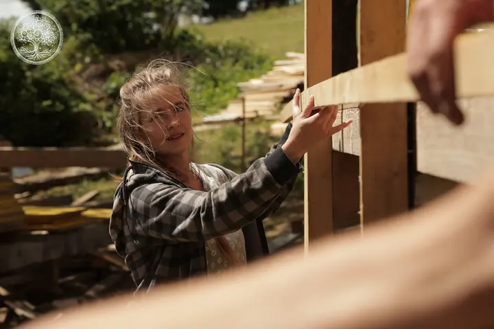 Ein Kind arbeitet mit einer Wasserwaage an einer Holzwand.